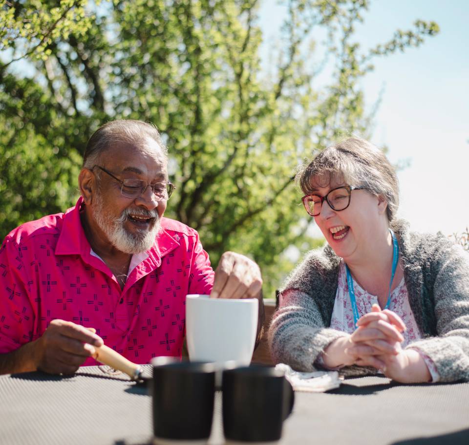 Visiting Angels caregiver enjoying a cup of tea outdoors with elderly client in Berkshire