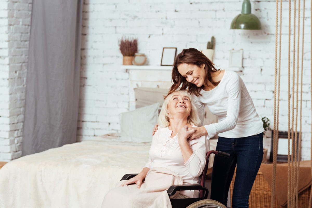 iStock-628754678-1200×801 caregiver sitting with an elderly client holding hands