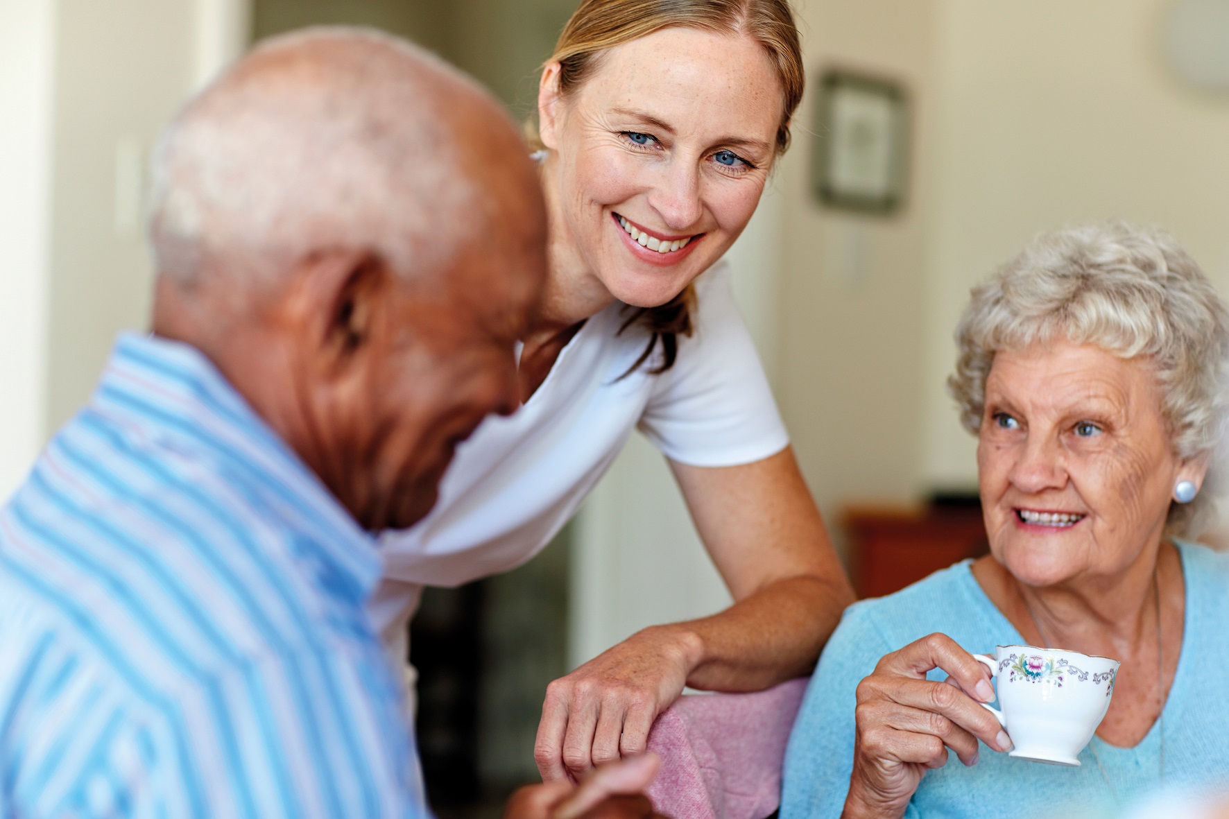 Caretaker with senior people in nursing home Caregiver with two senior clients