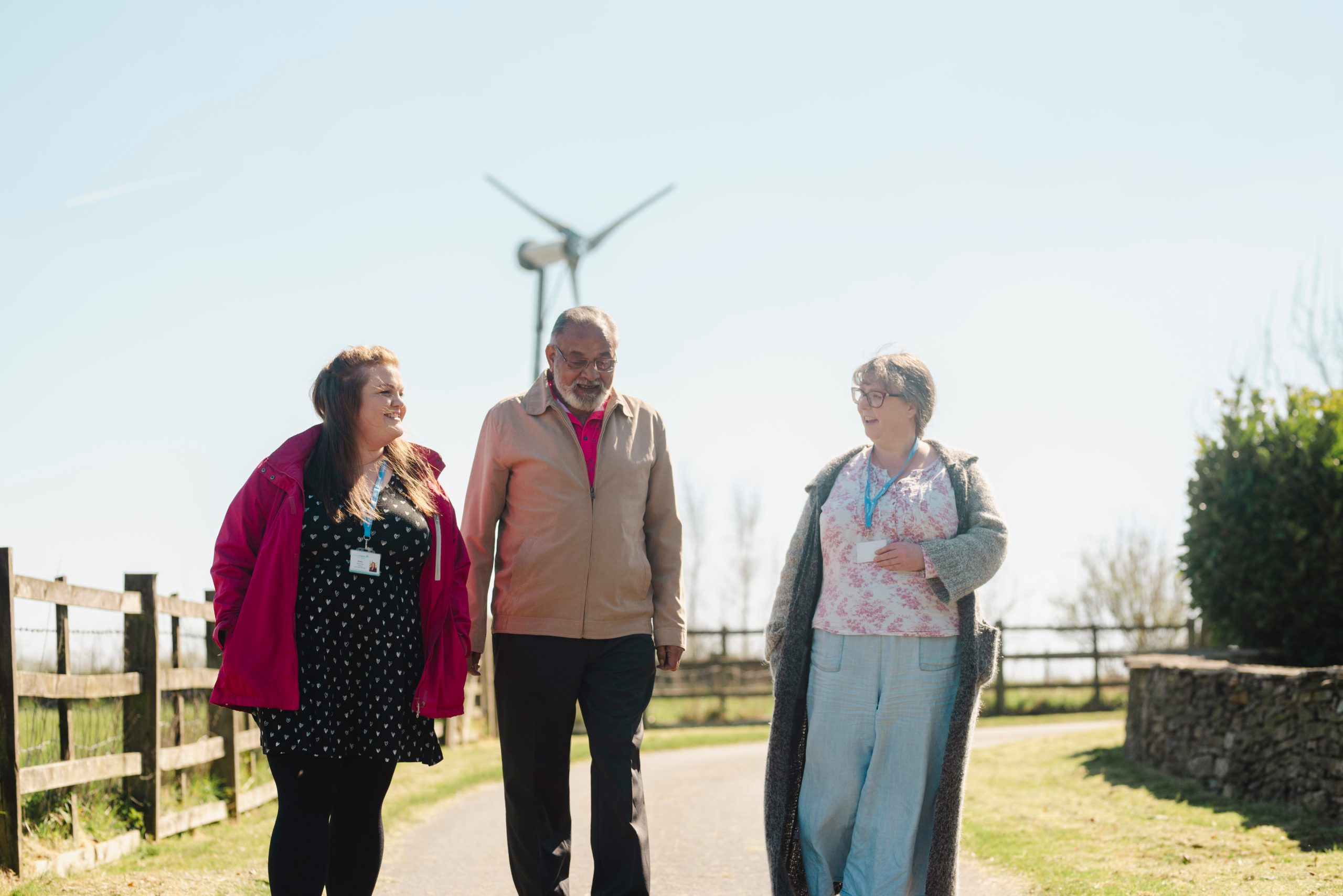 Caregivers and senior walking outdoors together.
