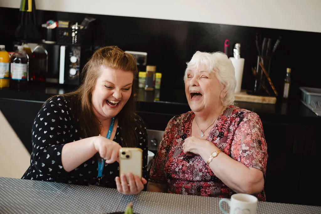 A Visiting Angels carer providing digital wellbeing support to an elderly woman at home in Witney, Oxfordshire — compassionate, professional, CQC rated home care