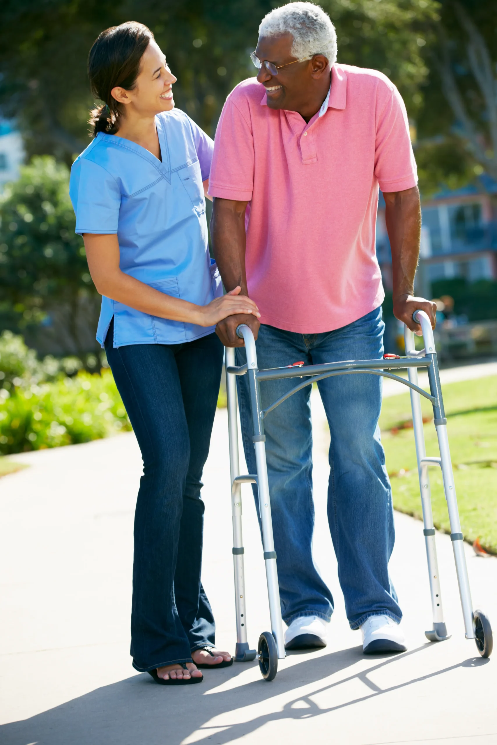 A Visiting Angels carer providing Parkinson’s care and mobility support to an elderly man outdoors in Oxford, Oxfordshire — compassionate, professional, CQC rated home care