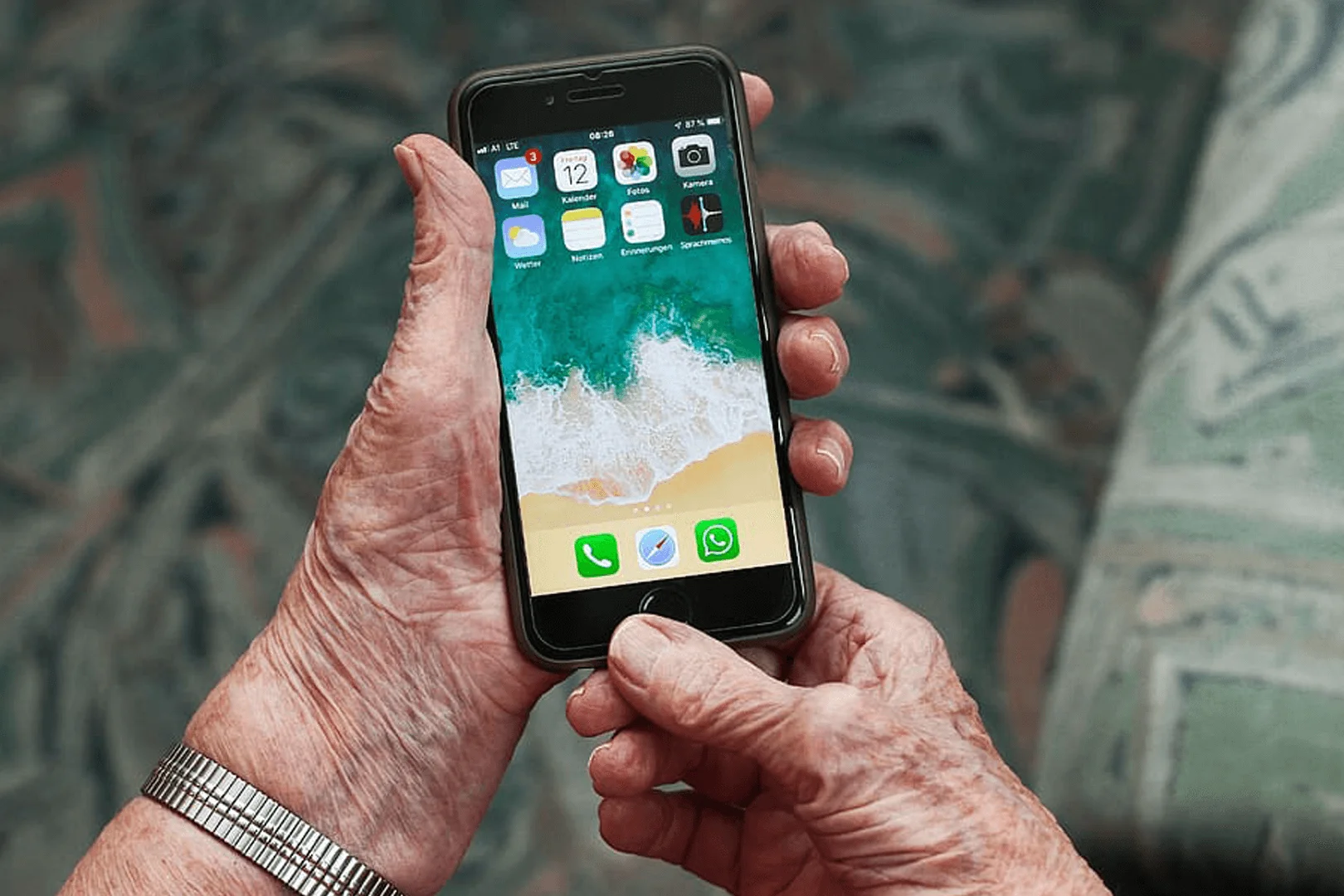An elderly adult using a smartphone with health apps — apps for seniors health Oxford support from Visiting Angels Oxford, compassionate, professional, CQC rated home care