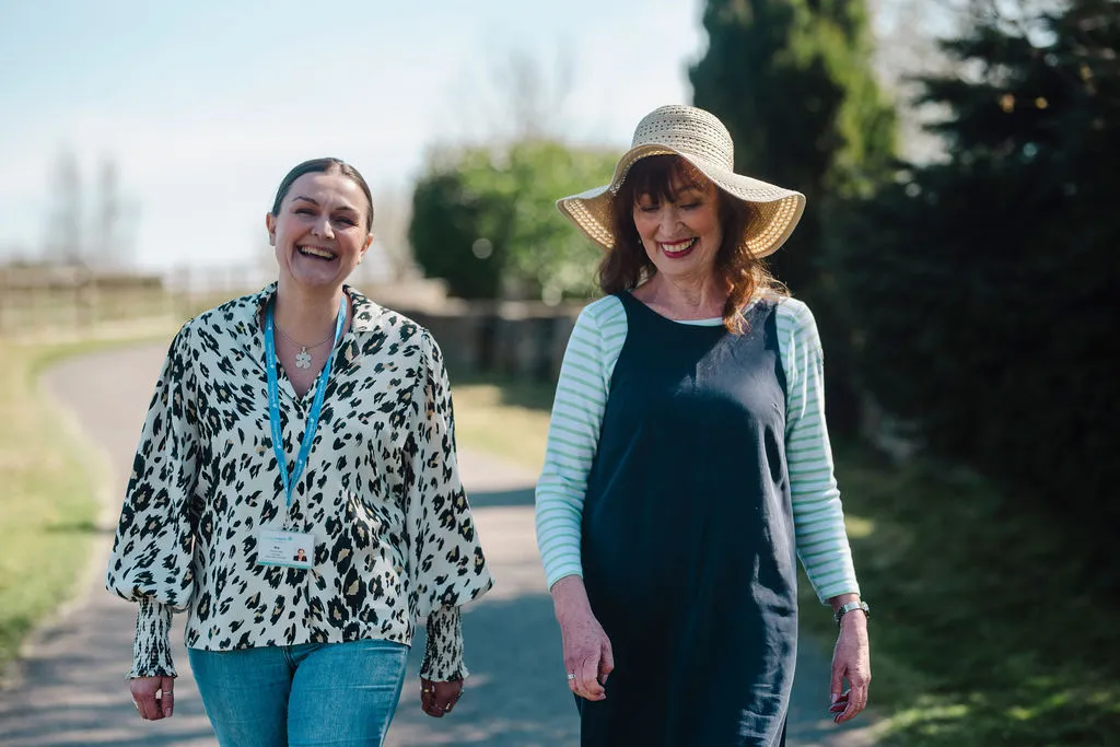 A Visiting Angels carer offering specialist dementia support to an elderly woman outdoors in Kidlington, Oxfordshire — compassionate, professional, CQC Good rated care