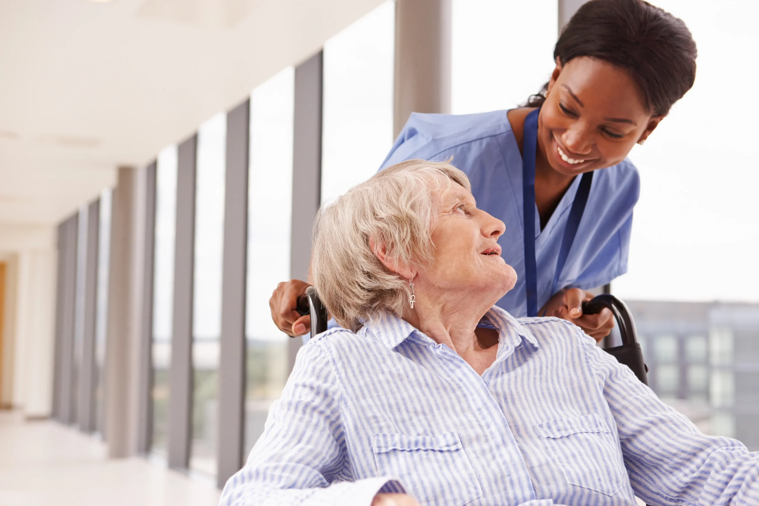 A Visiting Angels carer providing home care agency support to an elderly woman in a wheelchair in Bicester, Oxfordshire — compassionate, professional, CQC Good rated care