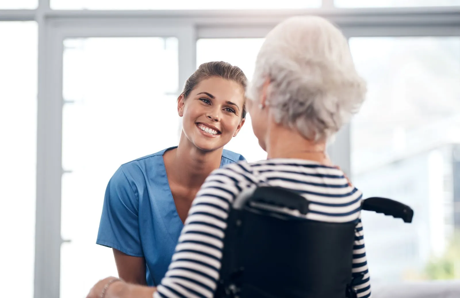 A Visiting Angels carer providing home care to an elderly woman in a wheelchair at home in Wheatley, Oxfordshire — compassionate, professional, CQC Good rated home care