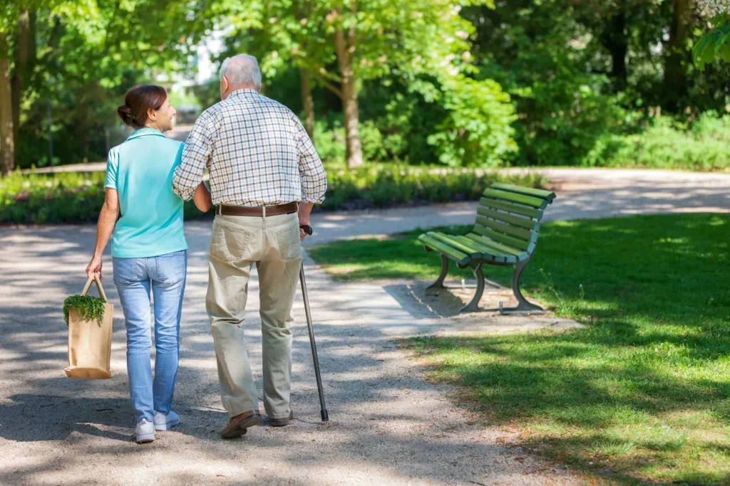 A Visiting Angels carer providing live‑in care services to an elderly man with a cane in Abingdon, Oxfordshire — compassionate, professional, CQC Good rated home care