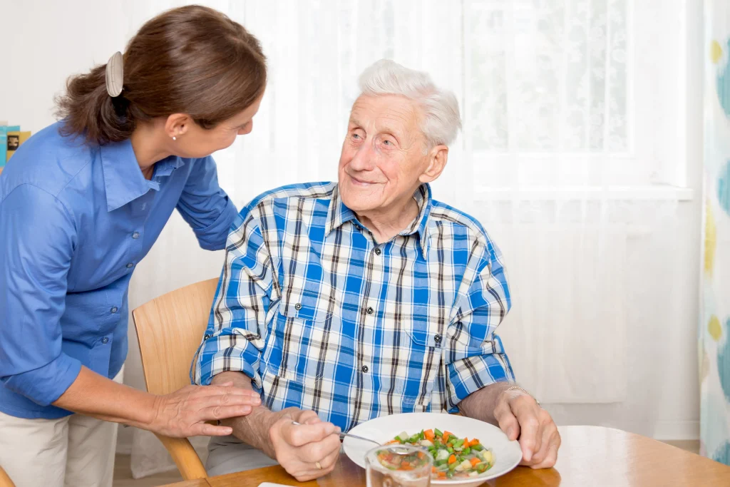A Visiting Angels carer providing personal care services to an elderly man at home in Oxford, Oxfordshire — compassionate, professional, CQC rated home care