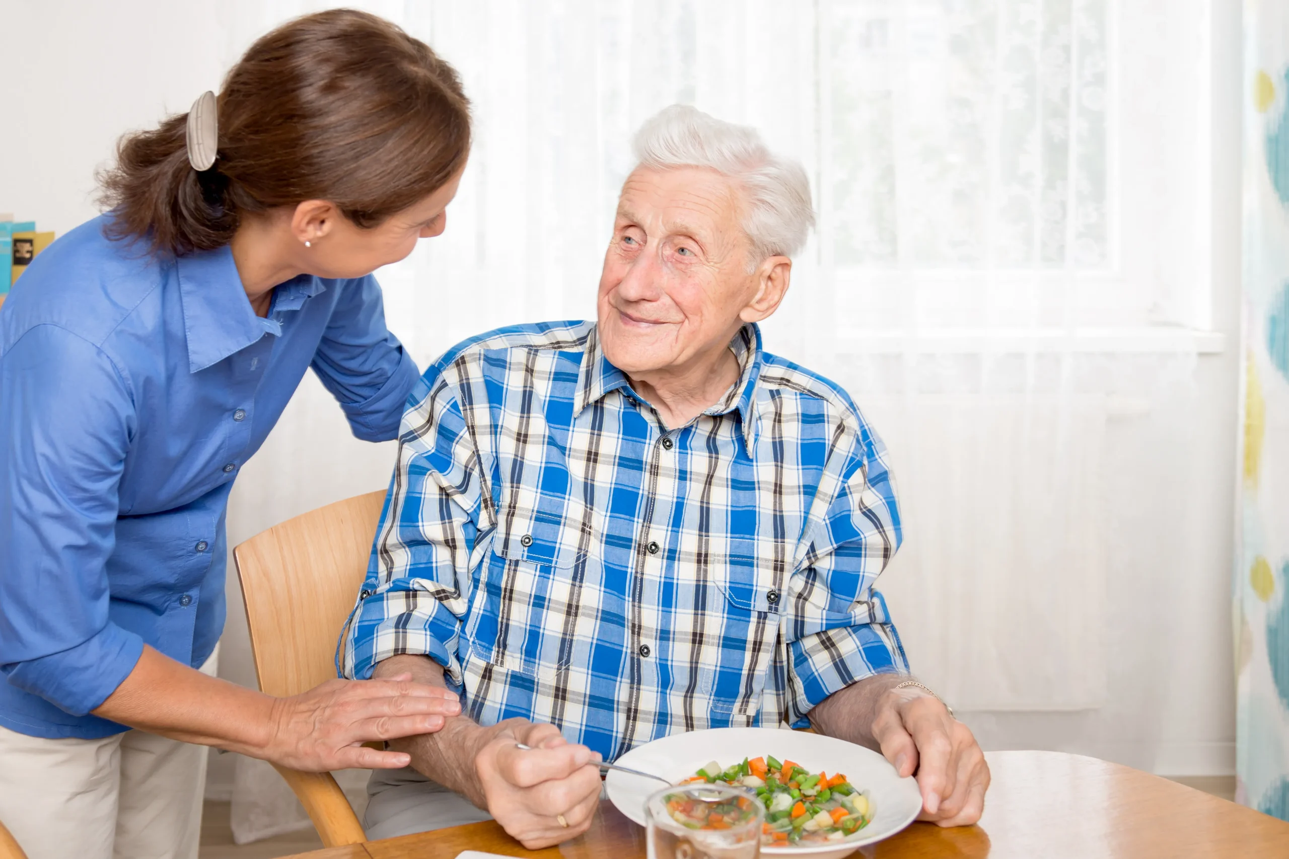 A Visiting Angels carer providing personal care services to an elderly man at home in Oxford, Oxfordshire — compassionate, professional, CQC rated home care