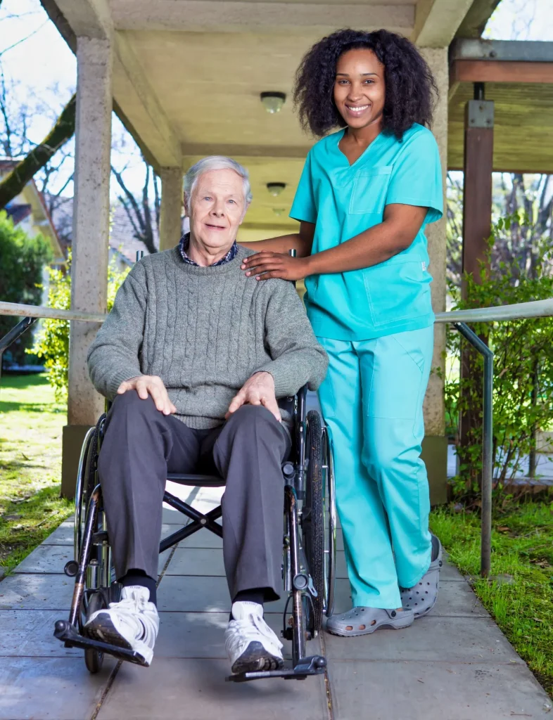 A Visiting Angels carer providing respite care services to an elderly man in a wheelchair at home in Oxford, Oxfordshire — compassionate, professional, CQC rated home care
