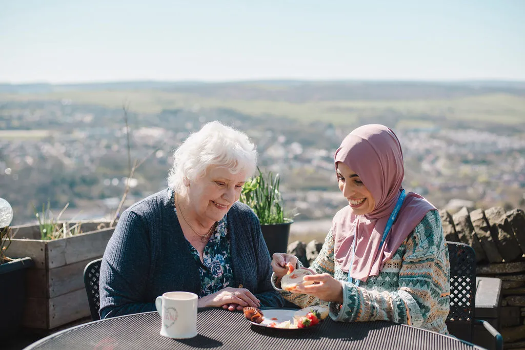 A Visiting Angels carer providing dementia care support to an elderly woman at home in Oxfordshire — compassionate, professional, CQC rated home care
