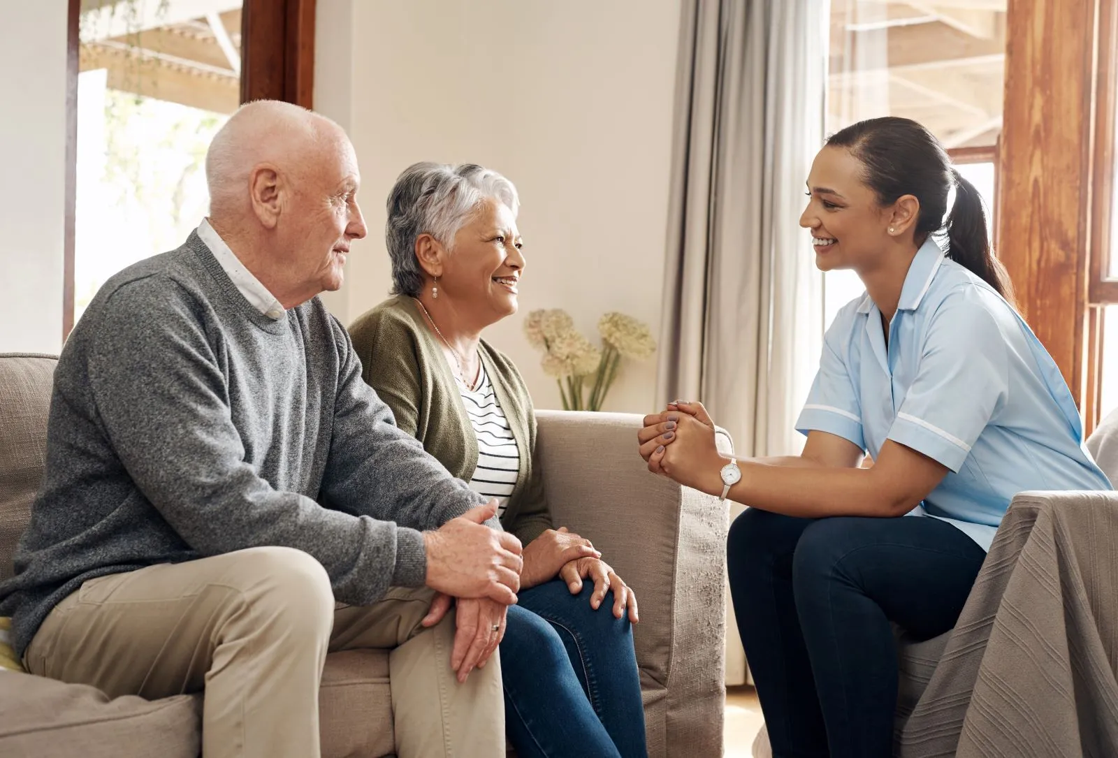 A Visiting Angels carer providing family consultation and home care to an elderly couple at home in Bicester, Oxfordshire — compassionate, professional, CQC rated home care