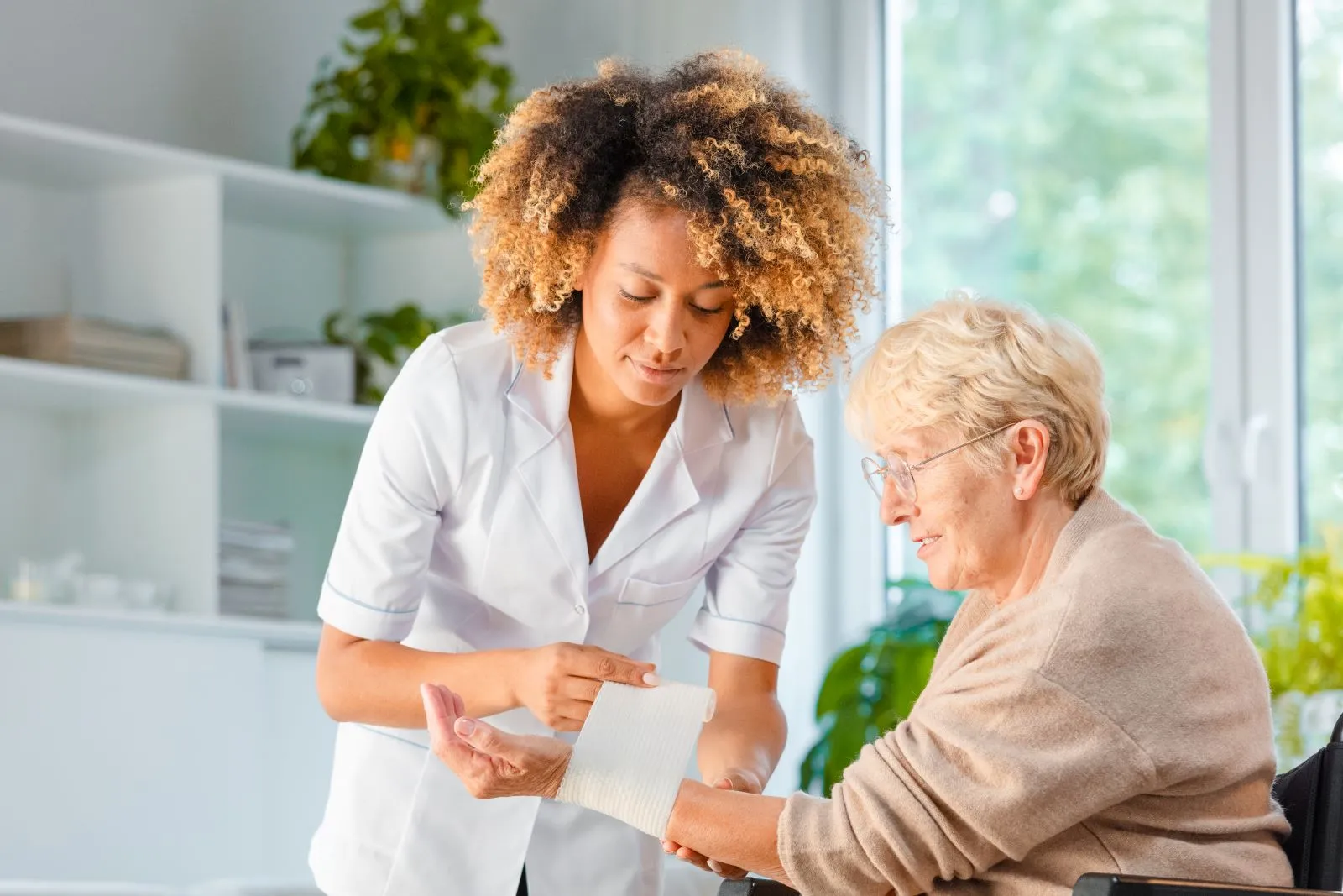 A Visiting Angels carer providing healthcare and medication support to an elderly woman in Bicester, Oxfordshire — compassionate, professional, CQC rated home care