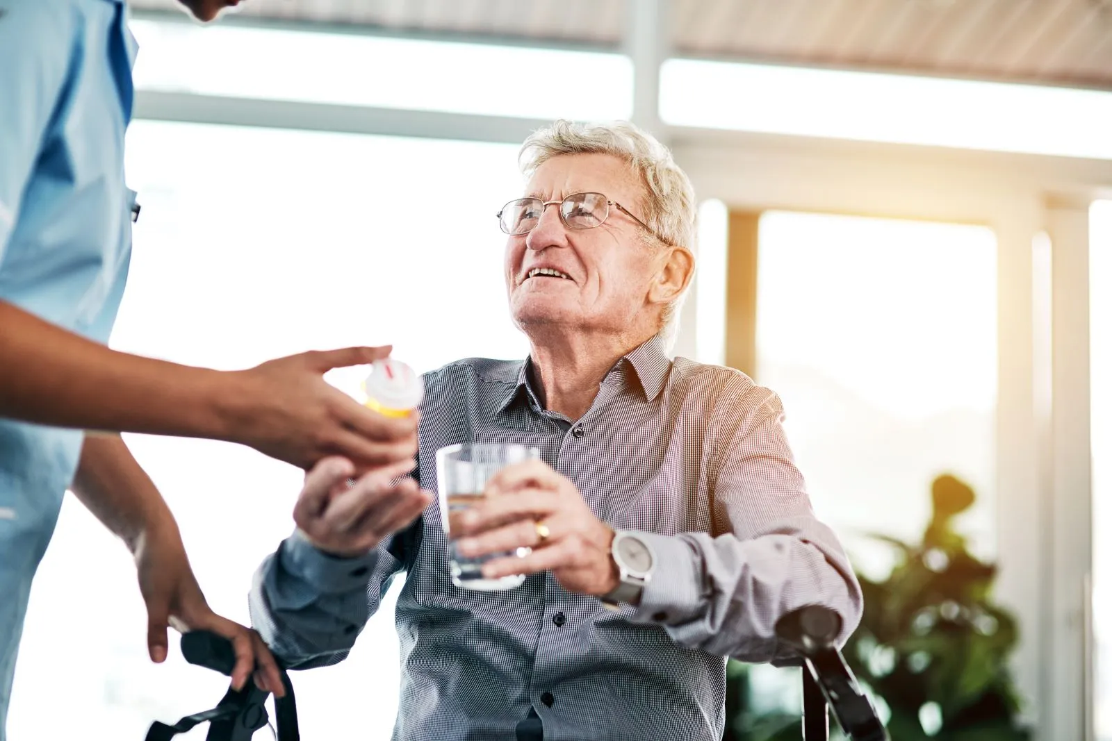 A Visiting Angels carer providing medication support and healthcare to an elderly man in Kidlington, Oxfordshire — compassionate, professional, CQC rated home care