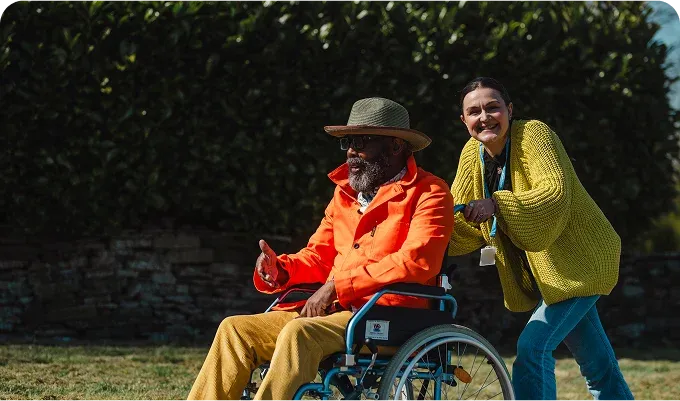 A Visiting Angels carer providing stroke recovery care to an elderly man in a wheelchair in Bicester, Oxfordshire — compassionate, professional, CQC rated home care