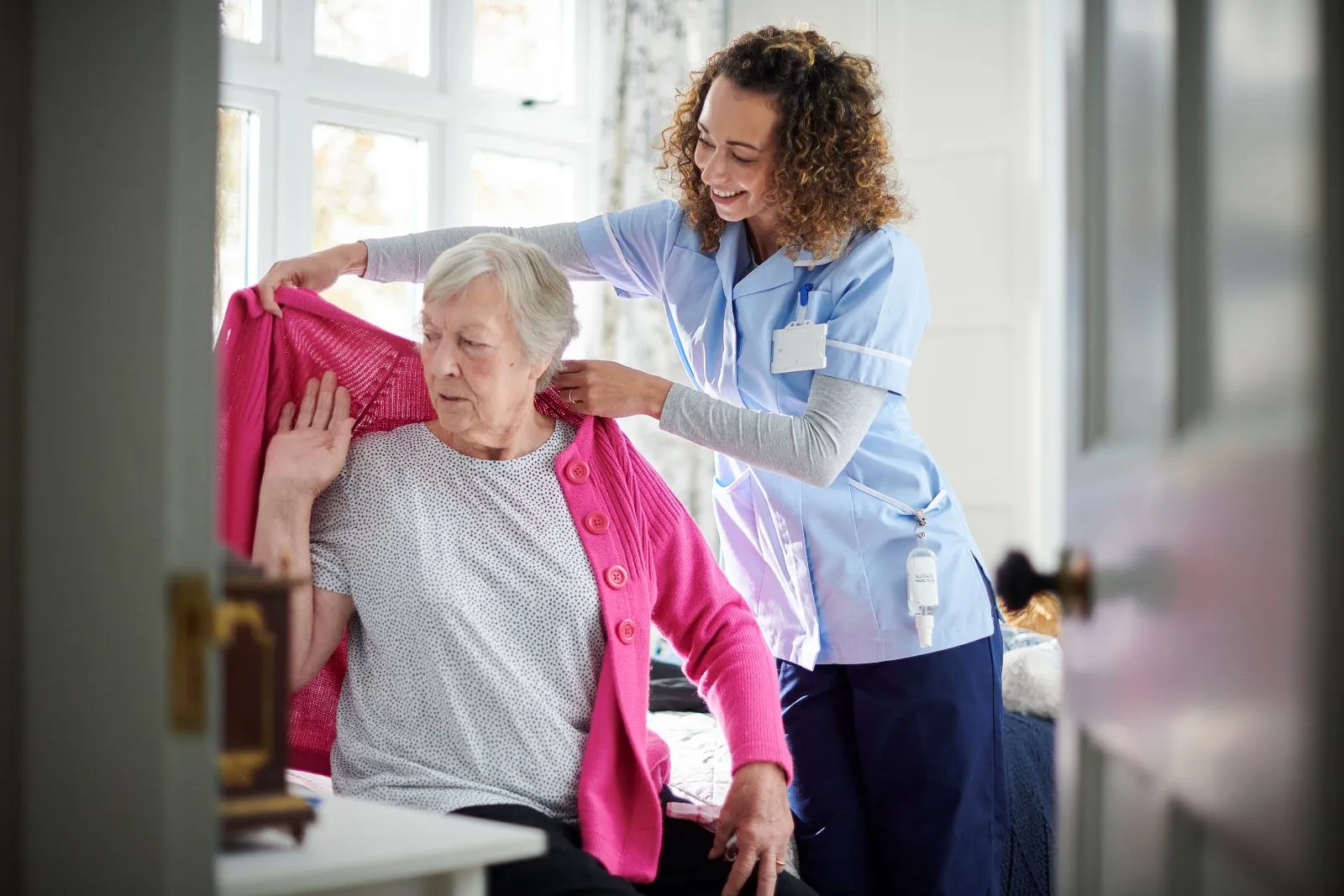 A Visiting Angels carer providing clinical care and medication support to an elderly woman in Thame, Oxfordshire — compassionate, professional, CQC rated home care