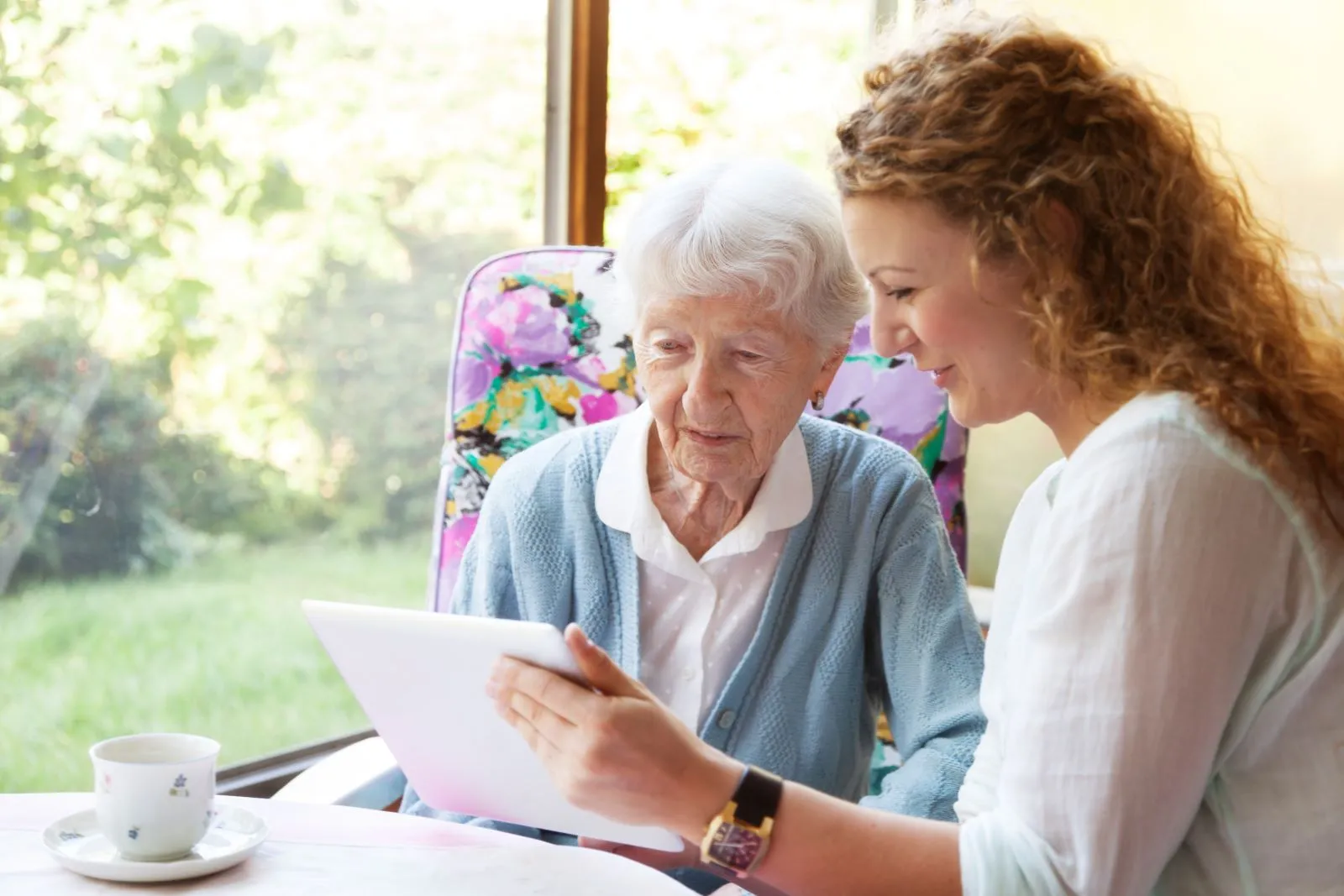 A Visiting Angels carer providing companionship and leisure care to an elderly woman at home in Woodstock, Oxfordshire — compassionate, professional, CQC rated home care