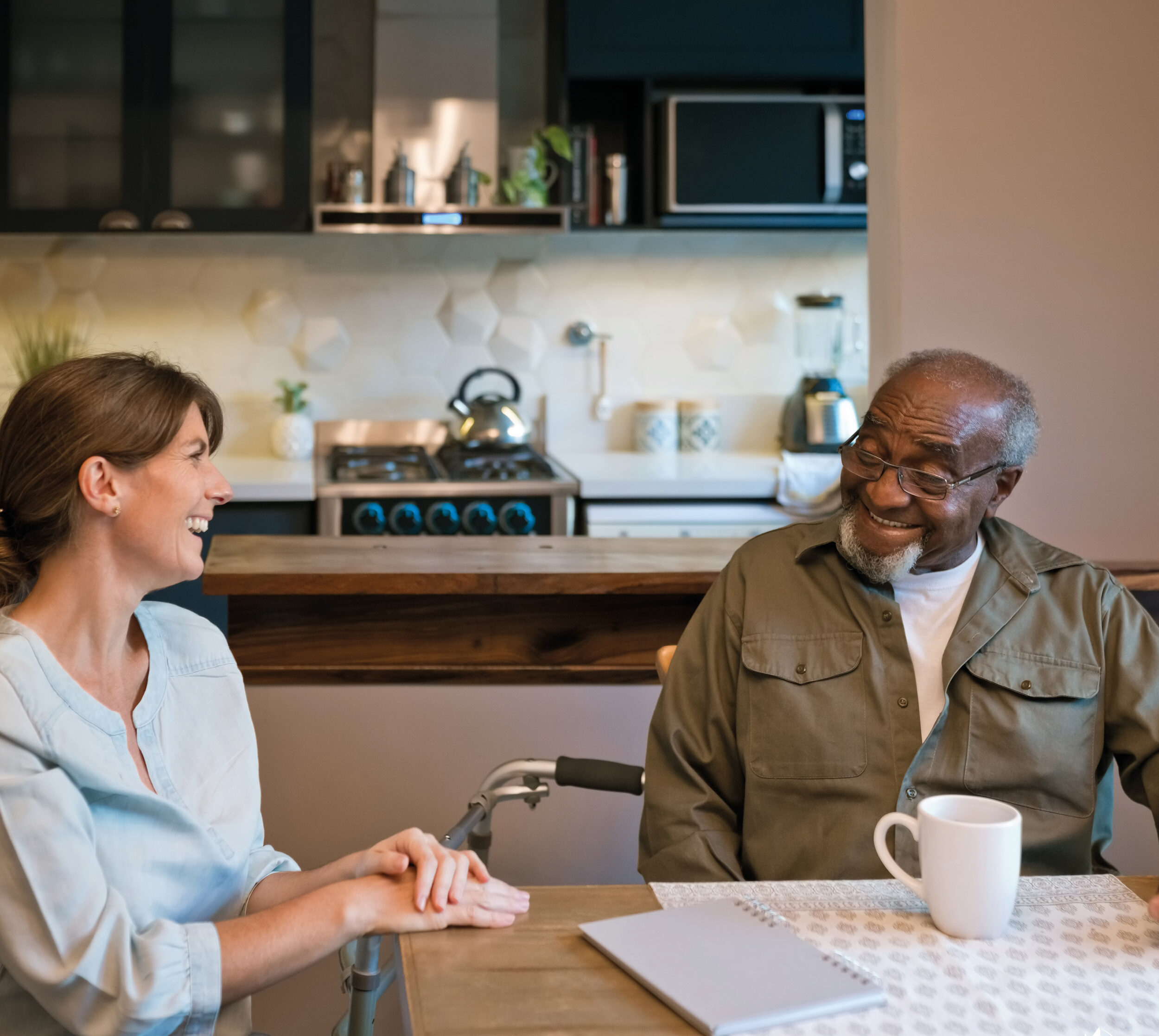 Caregiver with an elderly client holding hands