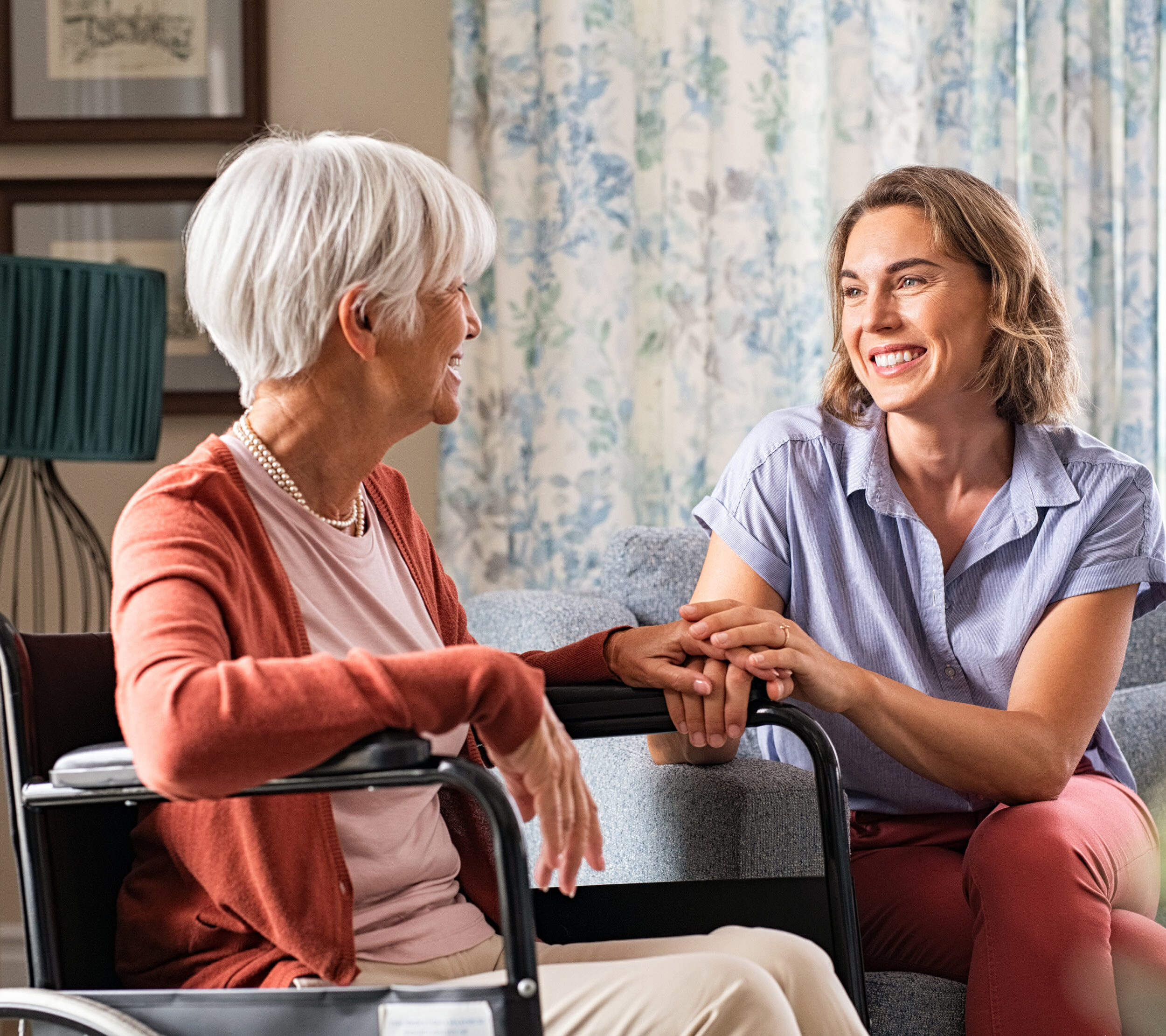 Caregiver with an elderly client holding hands